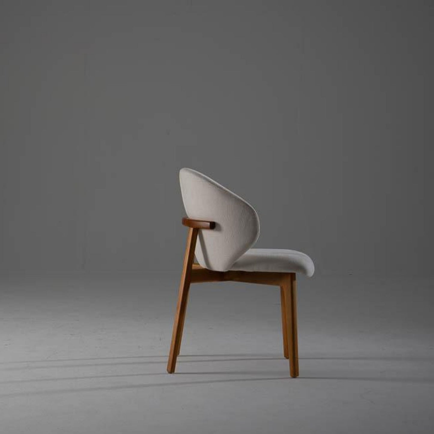 Side profile of the Kayra Dining Chair showcasing slim silhouette and tapered eucalyptus wood legs.